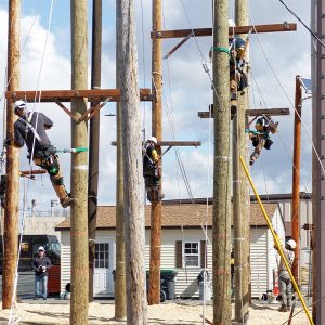 New apprentice line workers scale poles at National Grid...s eastern New York training facility in Schenectady in March 2023.