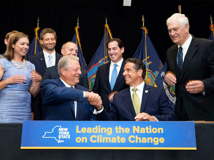 Then-N.Y. Gov. Andrew Cuomo and climate activist Al Gore shake hands after Cuomo signed New York's landmark climate protection act into law July 18, 2019. Five years later, an audit by the state comptroller faults progress toward the goals codified in that law.