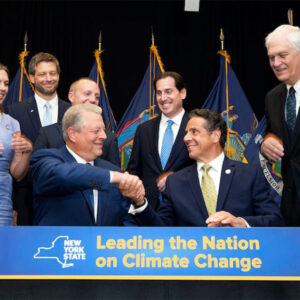 Then-N.Y. Gov. Andrew Cuomo and climate activist Al Gore shake hands after Cuomo signed New York's landmark climate protection act into law July 18, 2019. Five years later, an audit by the state comptroller faults progress toward the goals codified in that law.