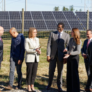 NYSERDA President Doreen Harris, center, wields a utility-scale pair of scissors at a ribbon-cutting for a milestone distributed solar project in New York on Oct. 17.