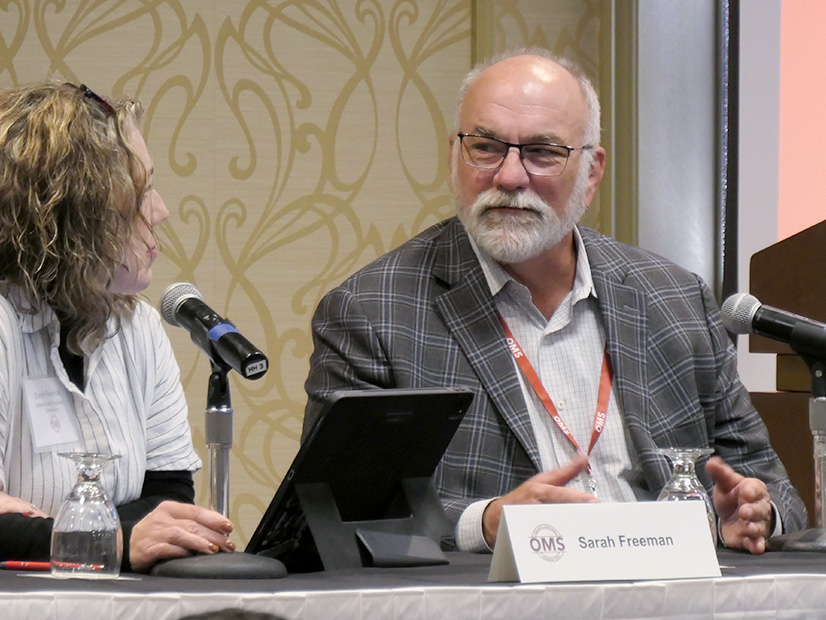 Indiana Utility Regulatory Commissioner Sarah Freeman (left) listens to MISO President and COO Clair Moeller at the Oct. 24 OMS annual meeting. 