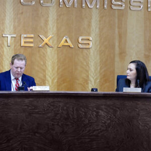 Lori Cobos with then-PUC Chair Peter Lake during a 2023 open meeting. 