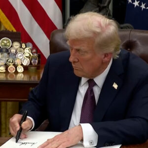 President Donald Trump signs executive orders in the Oval Office on Jan. 20.